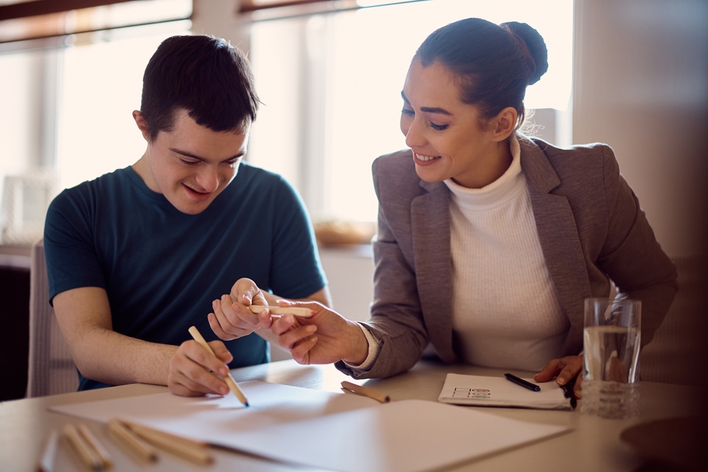 Happy,Down,Syndrome,Man,And,His,Psychologist,Drawing,Together,On